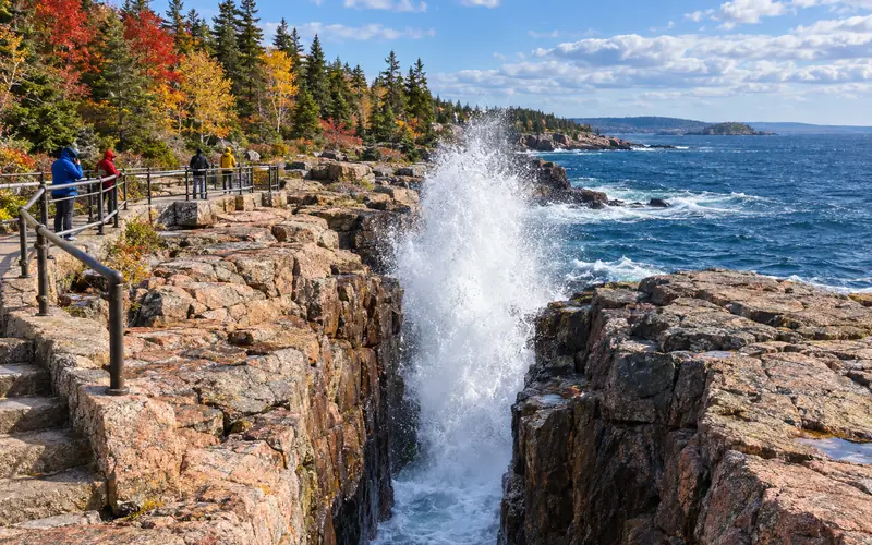 A wave bursting into spray at Thunder Hole's granite inlet