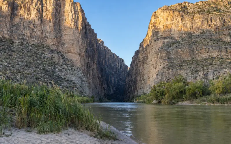 The Rio Grande flowing out of the narrow mouth of Santa Elena Canyon between sheer limestone walls
