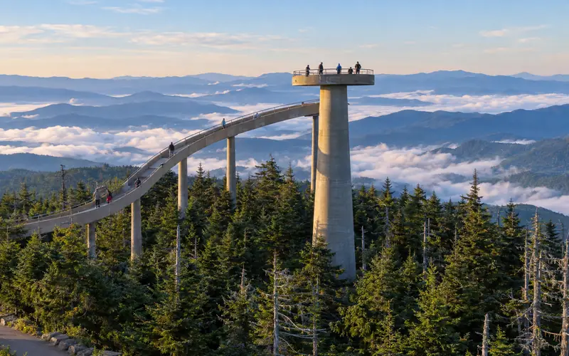 The curving ramp and observation tower on Kuwohi above a sea of clouds and blue ridges at sunrise