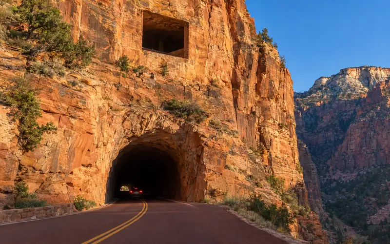 The Zion-Mount Carmel Highway entering the tunnel’s west portal, with a gallery window cut into the cliff above